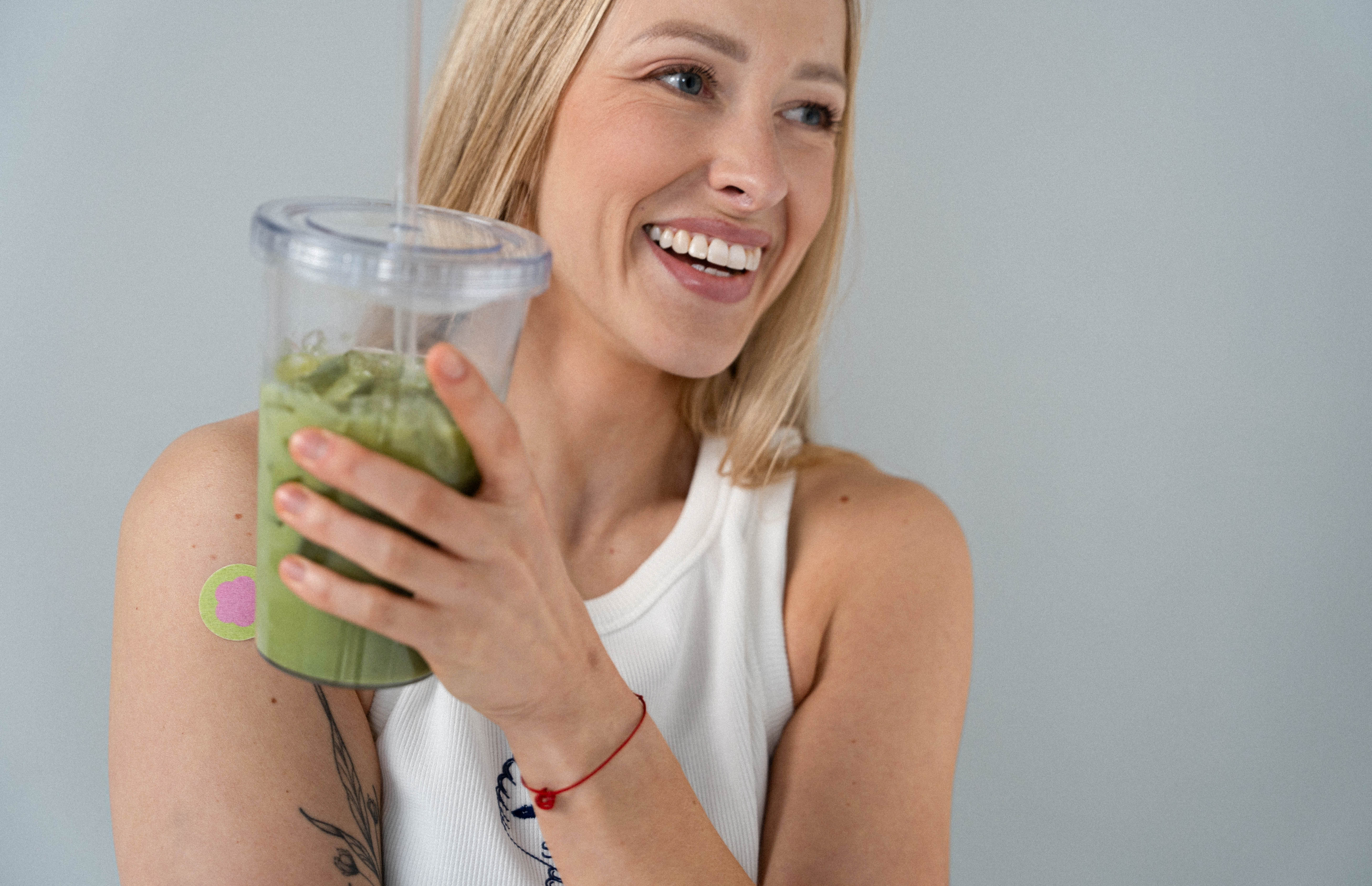 woman with a focus patch holding iced matcha
